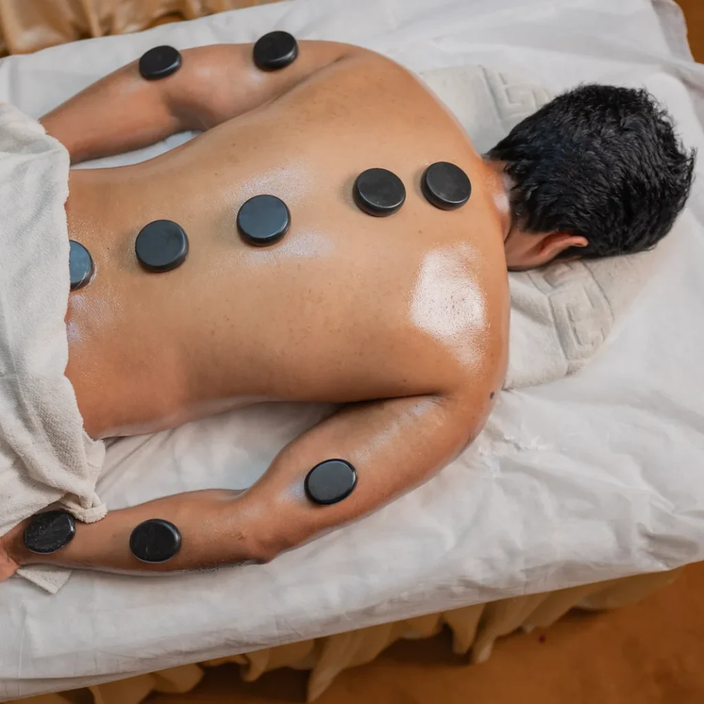 Smiling client lying on massage bed after hot stone therapy