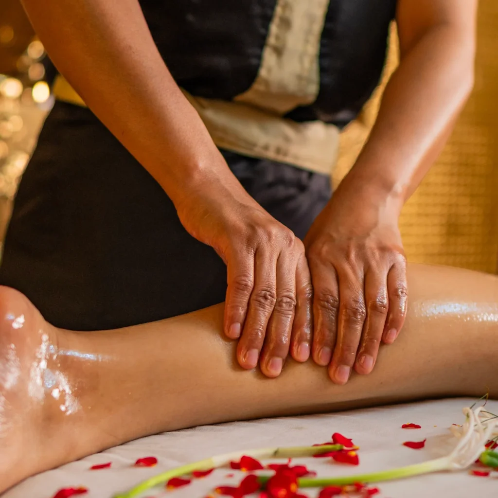 Therapist massaging client’s back using traditional Thai balm